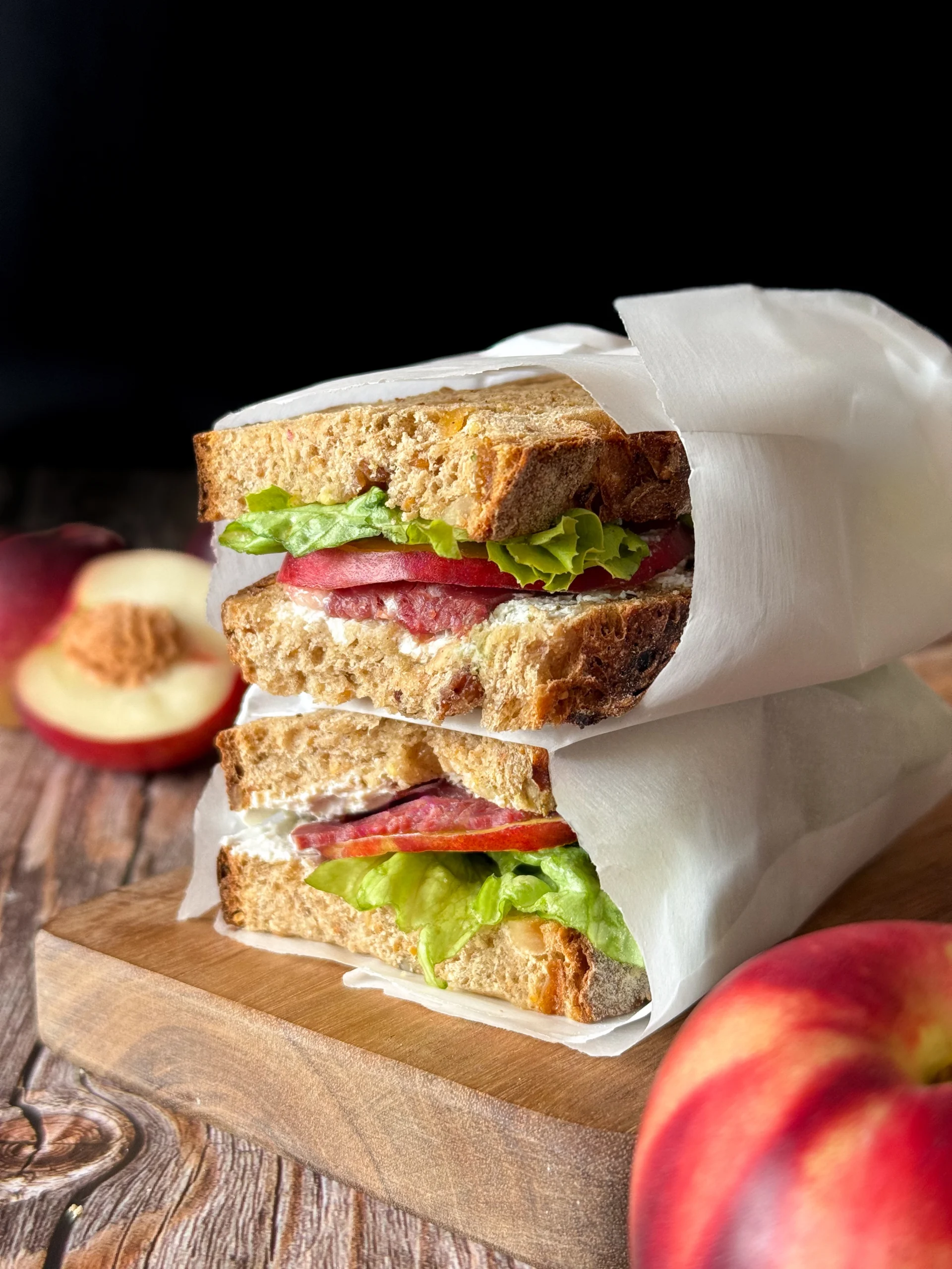 Sandwich du Sud ouest magret de canard nectarine fromage frais sur une table en bois